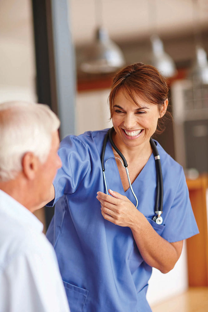 Woman nurse smiling warmly while talking with a senior patient