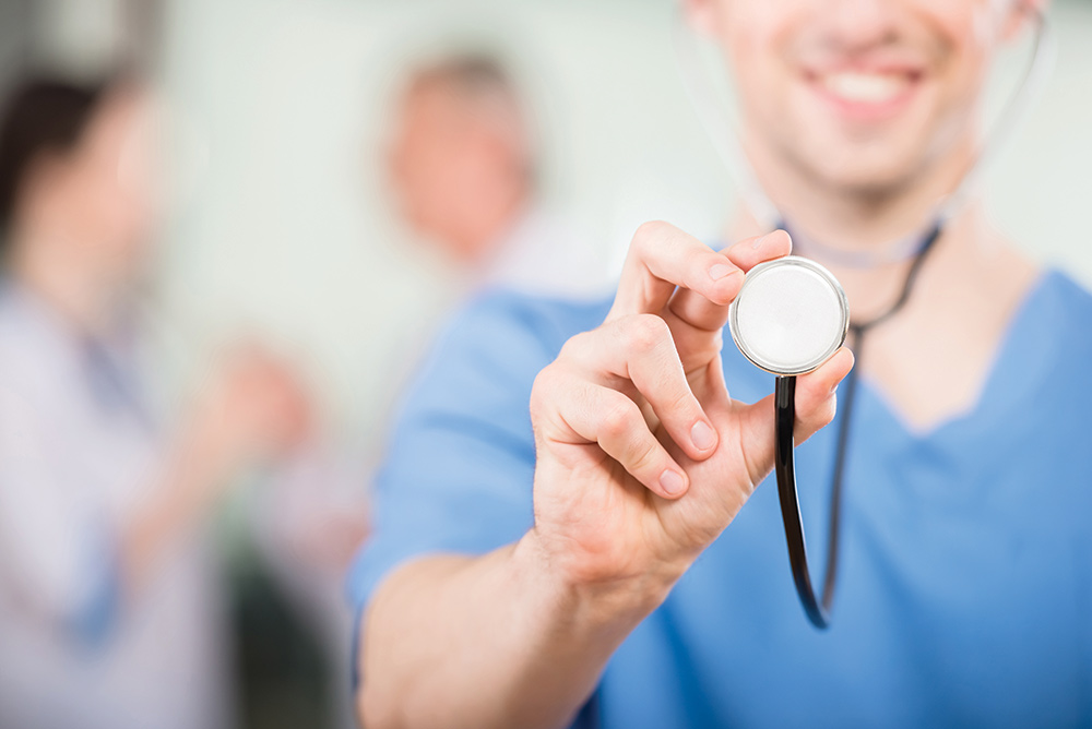 Female nurse holding up a stethoscope towards camera