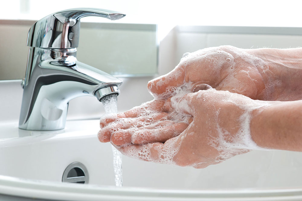 Washing soapy hands at a clean sink